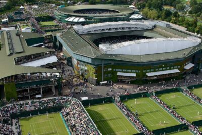 Aerial view of the Wimbledon Tennis Championships venue, showcasing multiple courts and spectators.
