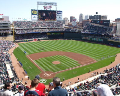 View of a baseball stadium during a game, showcasing a crowded audience and teams preparing on the field, associated with the MLB All-Star Game Travel Packages.