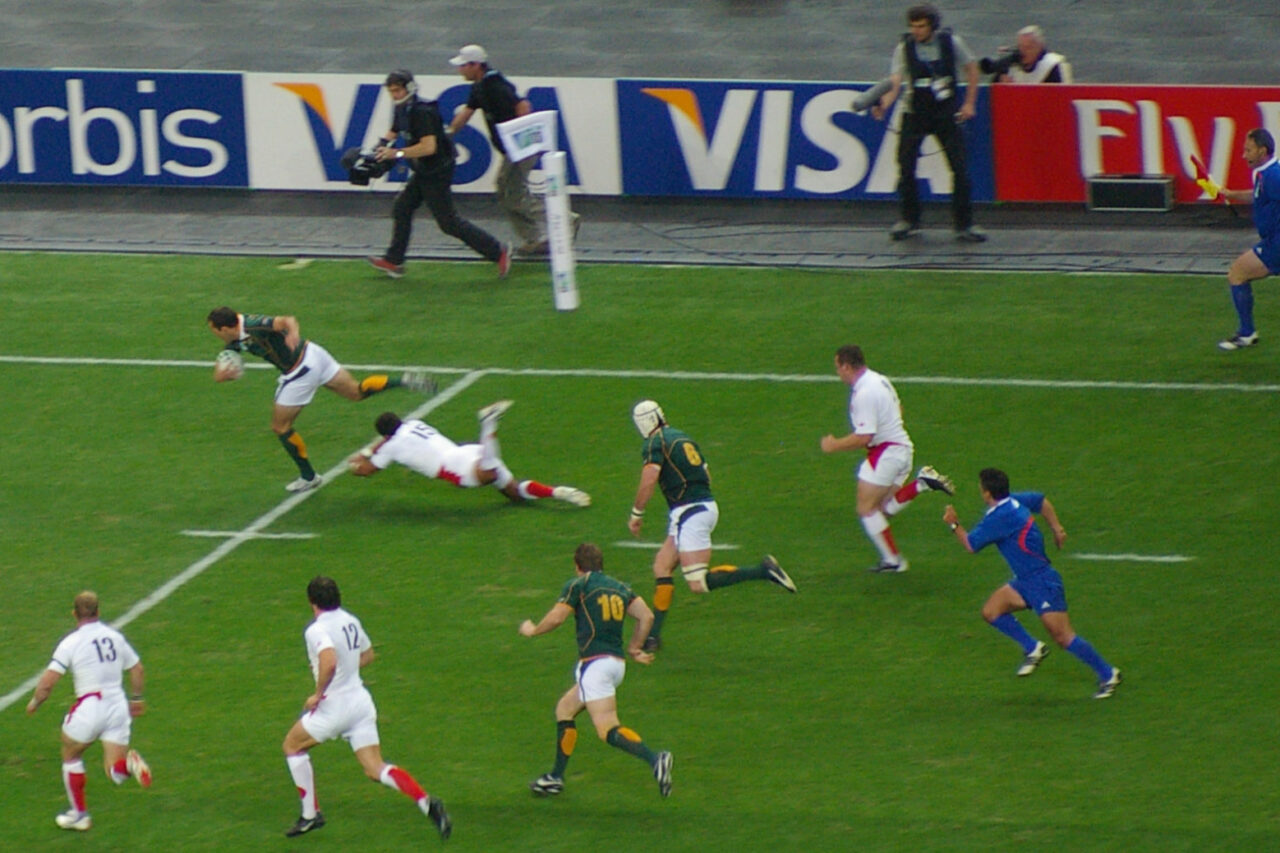 Players from different teams compete in an intense Rugby World Cup match, highlighting the global appeal of rugby and its travel, hotel, and ticket package opportunities.