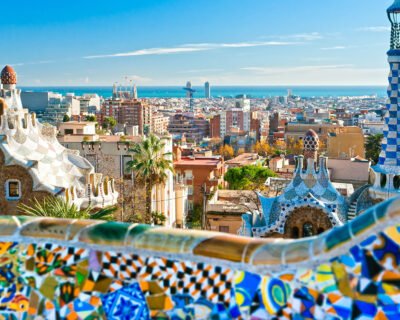 Panoramic view of Barcelona from Park Güell, showcasing vibrant mosaics and urban skyline, highlighting the city's architectural beauty relevant to potential Spanish Grand Prix travel packages.