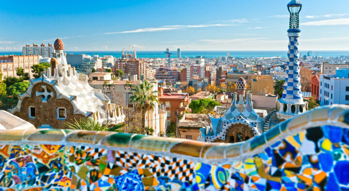Panoramic view of Barcelona from Park Güell, showcasing vibrant mosaics and urban skyline, highlighting the city's architectural beauty relevant to potential Spanish Grand Prix travel packages.