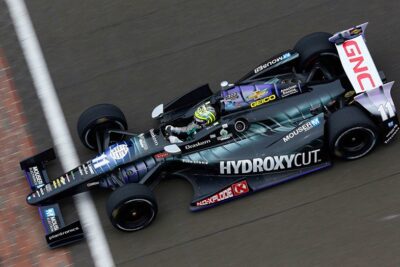 An IndyCar races around the track at the Indianapolis Motor Speedway during the Indy 500.