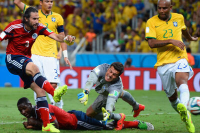 Intense moment at one of the best soccer tournaments in the world, showing a goalkeeper and players in a dynamic play on the field.