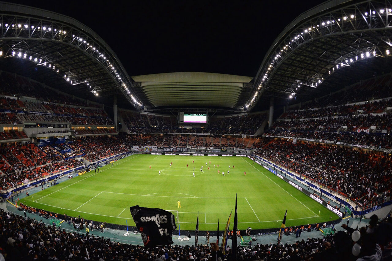 Nighttime soccer match underway at a large, illuminated stadium filled with spectators, suggesting one of the best group stage games at the World Cup.