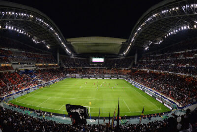 Nighttime soccer match underway at a large, illuminated stadium filled with spectators, suggesting one of the best group stage games at the World Cup.