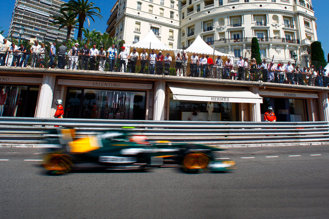 A Formula 1 race car speeds past a crowded viewing area in Monaco, capturing the excitement of the Las Vegas Grand Prix event.