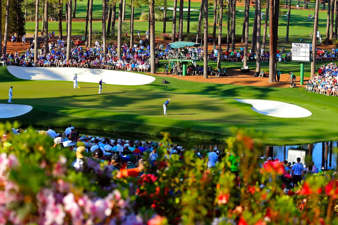 Golf players compete at the Masters, surrounded by a large audience and vibrant floral landscape, highlighting its status as a globally watched sporting event.