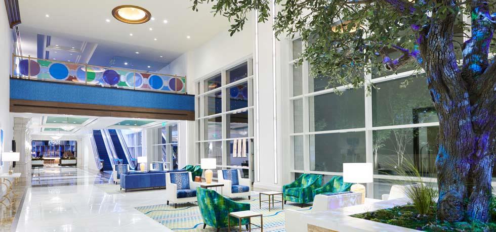 Luxurious lobby at the Fairmont Austin, featuring modern décor with blue and green accents, ideal for guests visiting the US Grand Prix in Austin, Texas.