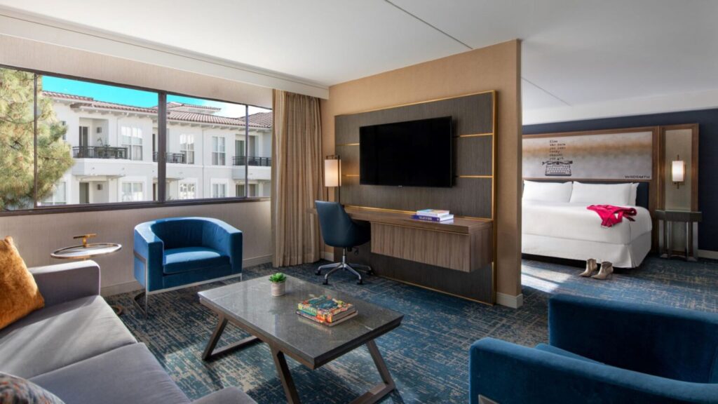 Luxurious hotel room at Hotel Dena in Pasadena, California, featuring a stylish seating area and city views, ideal for visitors attending the Rose Bowl.