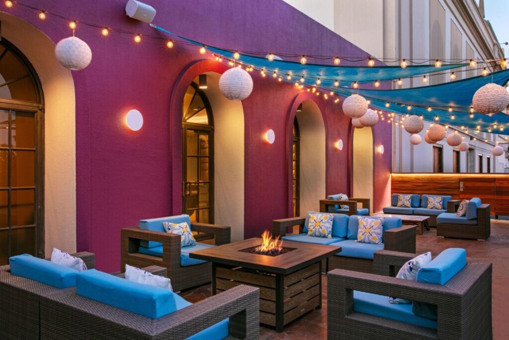 Luxurious patio seating area with fire pit at Hotel Dena, a Marriott hotel in Pasadena, perfect for visitors looking for accommodations during the Rose Bowl.