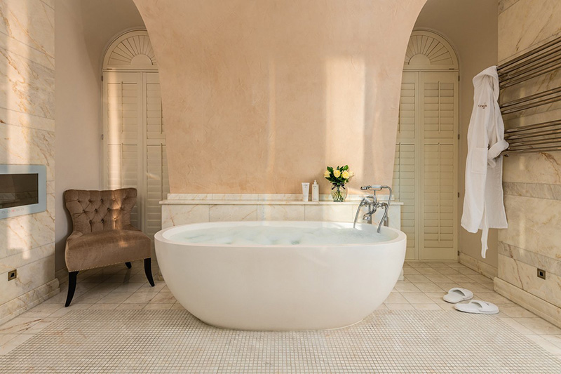 Elegant bathroom featuring a large, round, freestanding tub in a luxurious hotel.