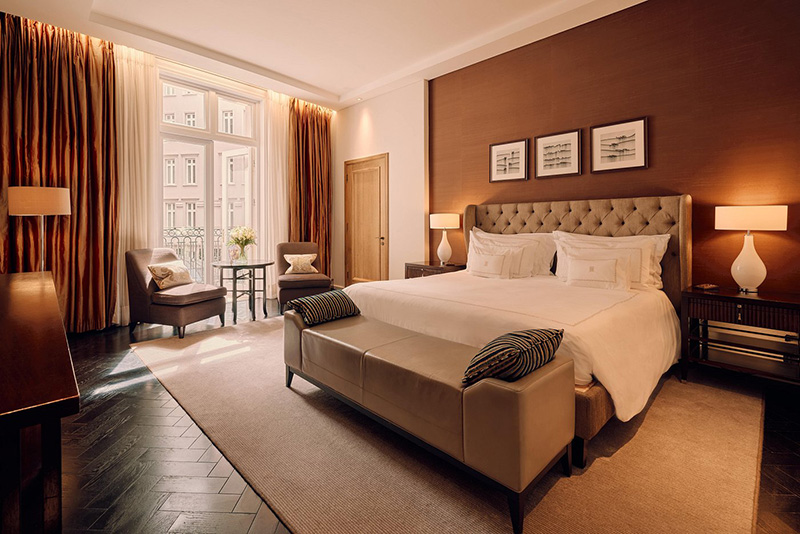 Elegant room at the Corinthia Hotel in London, featuring a plush king-sized bed, cozy seating area, and stylish decor, ideal for guests visiting the Wimbledon Championships.