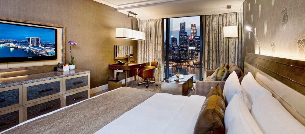 Luxurious hotel room with modern furnishings and a striking view of the Singapore skyline, ideal for guests visiting during the Singapore Grand Prix.