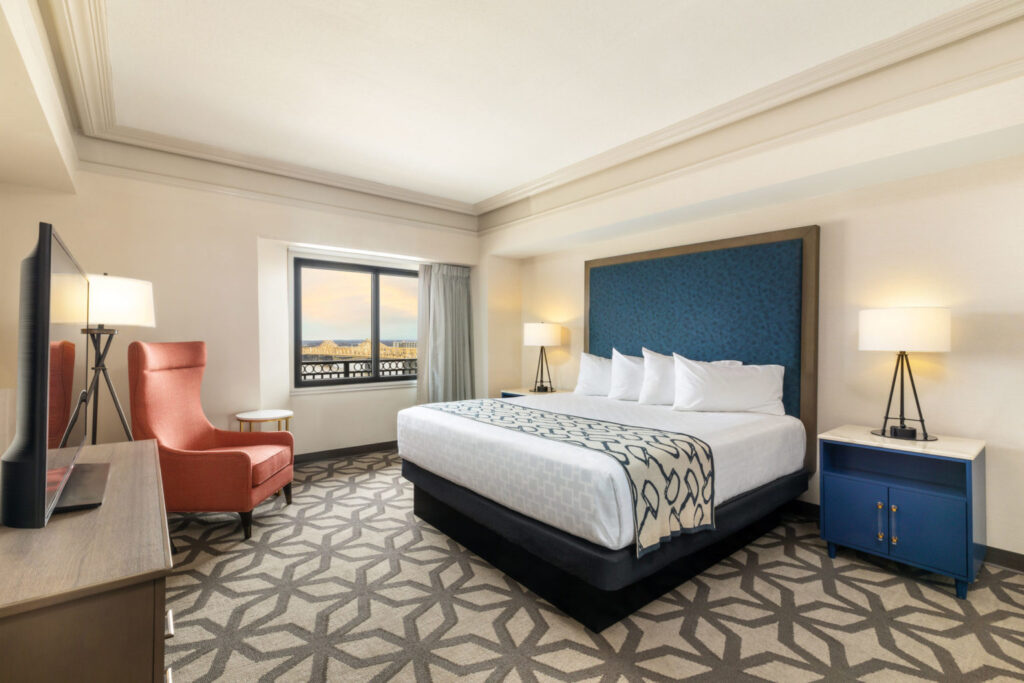 Luxurious hotel room at the Galt House Hotel in Louisville, showcasing a large bed with stylish linens, seating area with a view, and elegant decor, ideal for Kentucky Derby attendees.