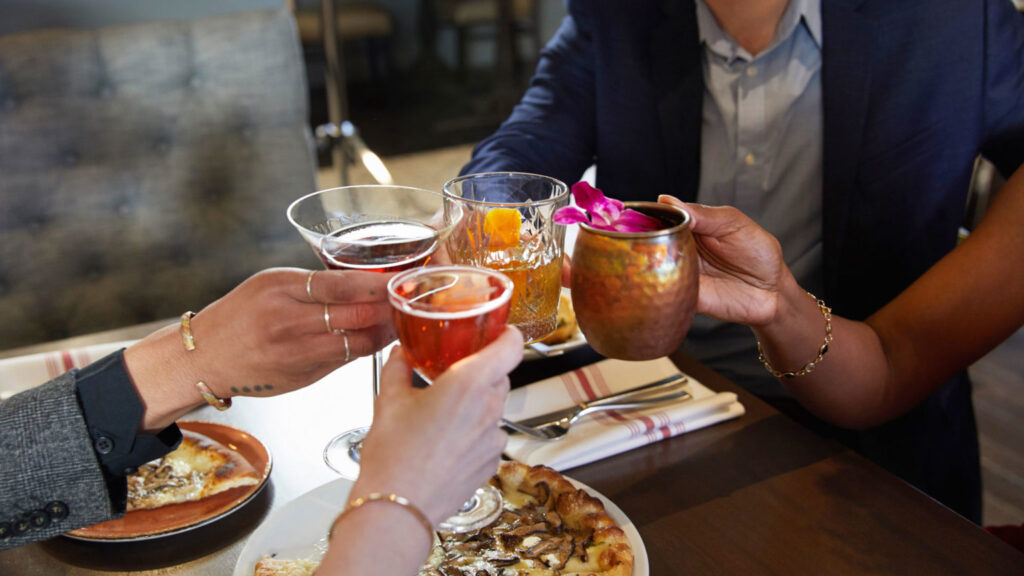 People enjoy drinks and a meal together in a stylish setting at the Galt House Hotel's Walker's Exchange in Louisville, a great choice for visitors planning to attend the Kentucky Derby.