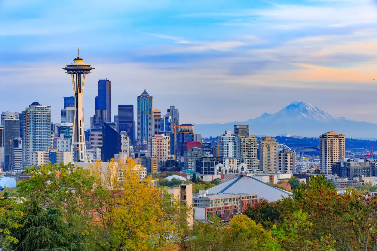 View of Seattle showing the iconic Space Needle, Lumen Field, and modern skyscrapers with Mount Rainier in the background, highlighting World Cup venues in the USA.