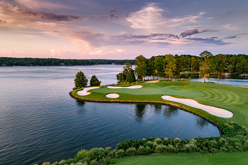 Aerial view of Ritz-Carlton Reynolds, Lake Oconee, showing a scenic golf course with lush greens and sand bunkers, surrounded by a serene lake, located near Greensboro and Augusta, Georgia.