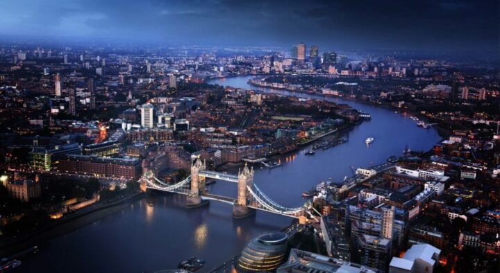 Nighttime aerial view of London highlighting the River Thames, Tower Bridge, and the vibrant cityscape, used for the Wimbledon London area map.