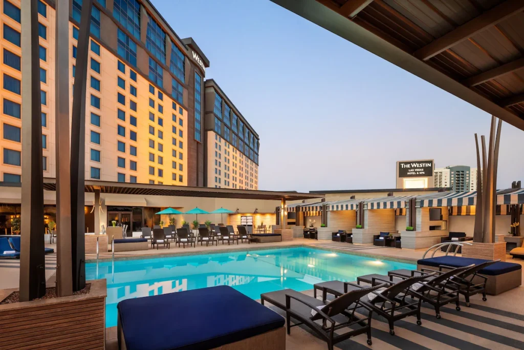 Dusk view of The Westin Las Vegas Hotel & Spa, featuring an outdoor pool with lounge chairs and cabanas, located at 160 East Flamingo Road, ideal as Las Vegas Grand Prix accommodation.