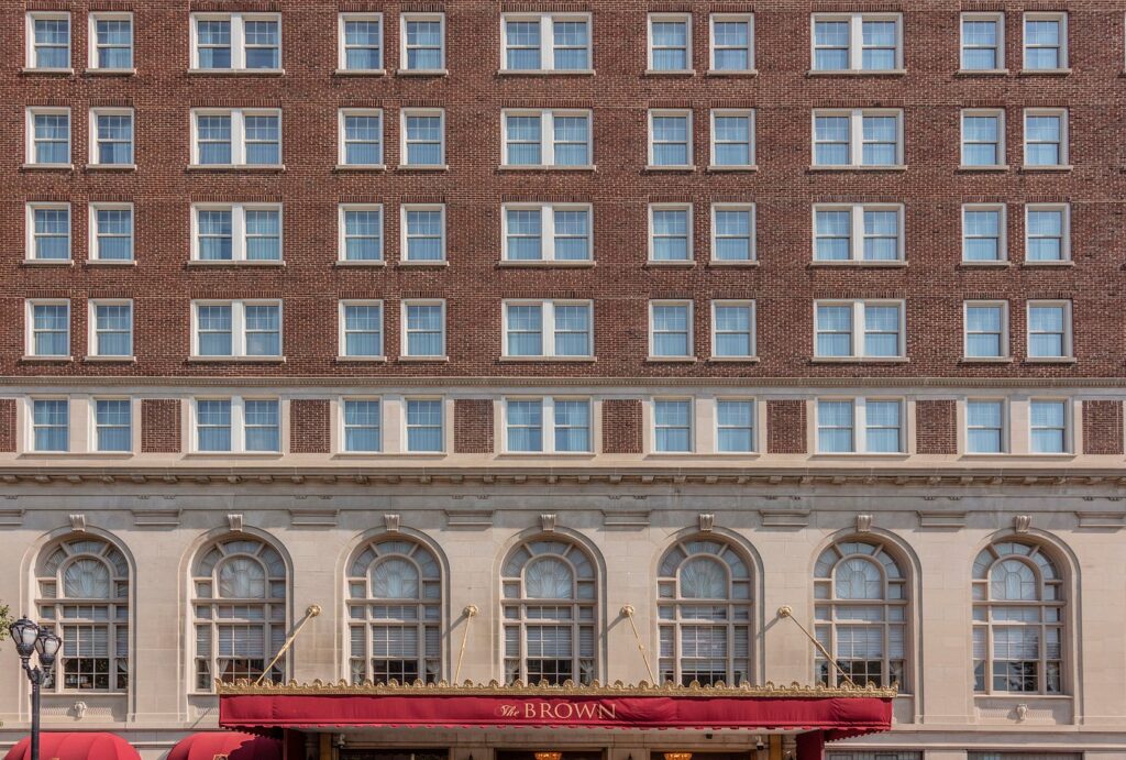 Exterior view of The Brown Hotel in Louisville, Kentucky, a potential accommodation for visitors attending the Kentucky Derby, showcasing its classic architectural style and multiple-storied facade.