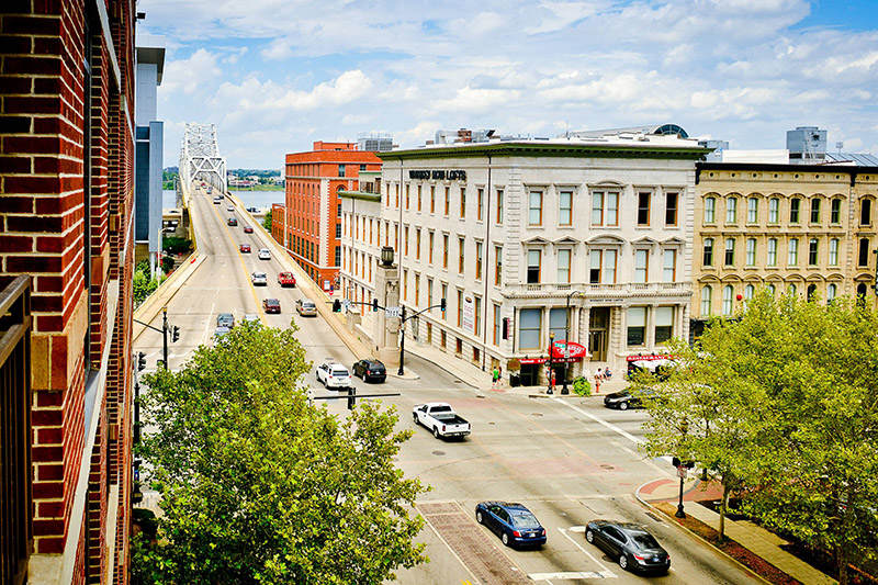 View of a busy street lined with historic buildings near the Courtyard by Marriott in downtown Louisville, a convenient location for Kentucky Derby accommodations.