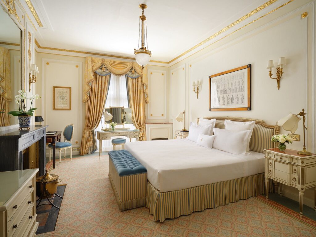 Luxury hotel room at The Ritz London, featuring an elegantly designed deluxe king bedroom with ornate golden details, ideal for guests visiting the Wimbledon Championships.