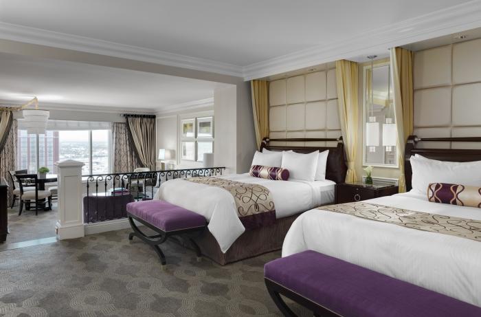 Luxurious room at The Venetian Resort in Las Vegas, featuring two queen beds with plush white bedding, elegant décor, and a city view, ideal for guests visiting for the Las Vegas Grand Prix.