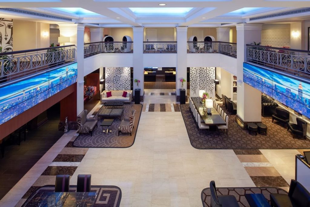 Interior view of the spacious lobby at The Lexington Hotel, Autograph Collection, showcasing elegant seating areas and luxurious decor, perfect for guests visiting New York for the US Open Tennis event.