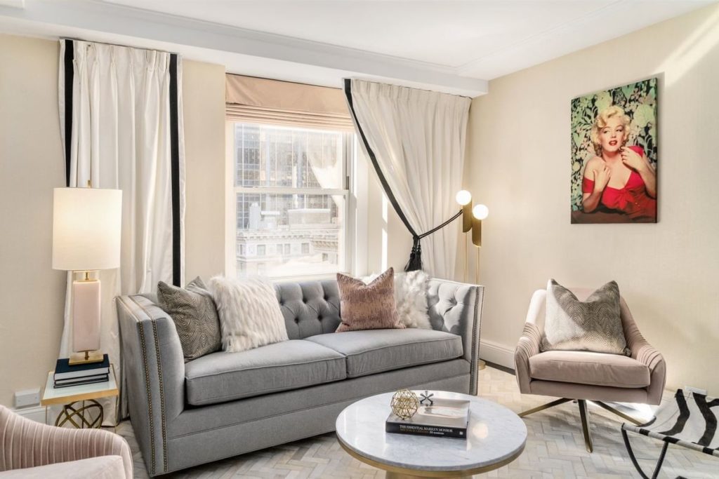 Elegant living room in The Lexington Hotel, featuring a modern sofa, stylish armchair, and a portrait of Marilyn Monroe, ideal for guests attending the US Open Tennis in New York.