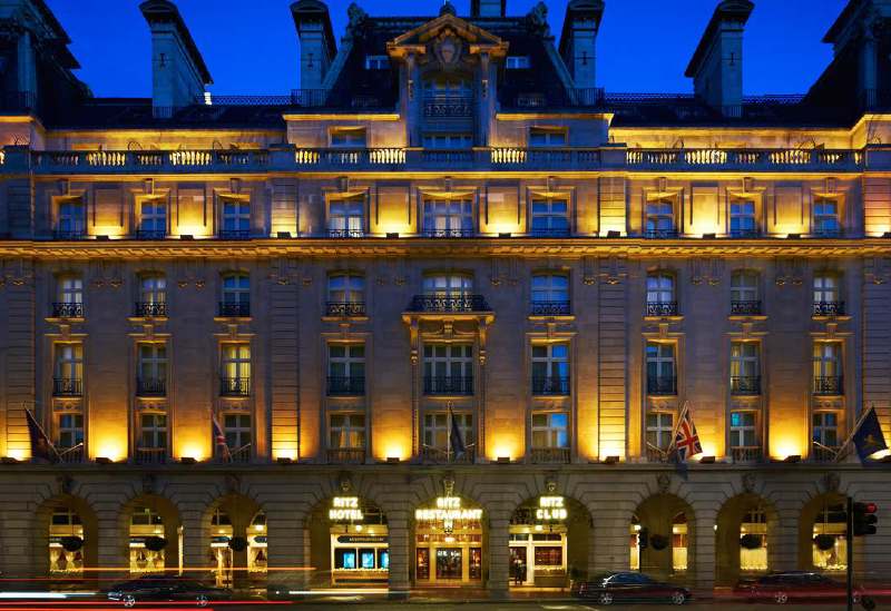 Exterior view of The Ritz London at night, showcasing its illuminated facade and entrance, ideal for guests attending the Wimbledon Championships.