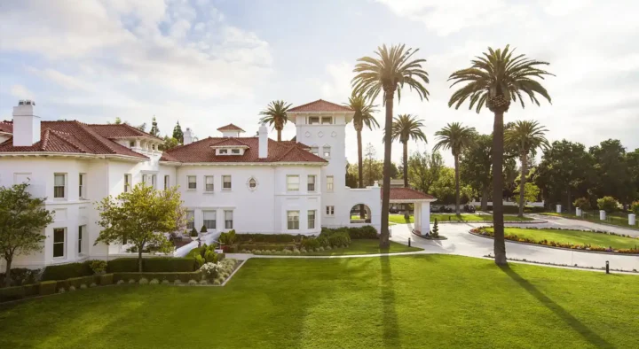 Luxury hotel with sprawling manicured lawns and towering palm trees, ideal for booking superb accommodations in the Santa Clara & South Bay Area for Super Bowl events.