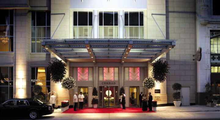Evening view of a luxury hotel entrance in Indianapolis, lit up and busy, likely accommodating guests for the Indianapolis 500 event.