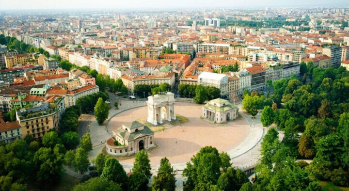 Aerial view of a large city square in Milan, featuring an iconic arch and surrounding buildings, relevant for visitors connecting with the Italian Grand Prix in Monza.
