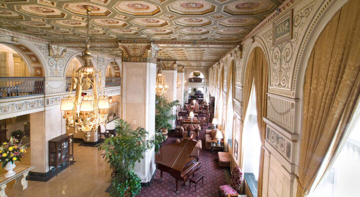 Luxurious hotel lobby in Louisville, decorated with ornate ceilings and classic furniture, offering upscale accommodations near Churchill Downs for Kentucky Derby visitors.