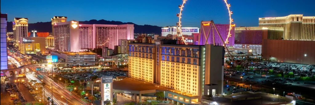 Panoramic evening view of the Las Vegas skyline featuring prominent hotels and a bustling street, highlighting the Westin Las Vegas Hotel & Spa on East Flamingo Road, ideal for the Las Vegas Grand Prix.