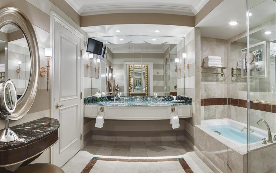 Luxurious bathroom at The Venetian Resort in Las Vegas, featuring a marble-top double sink, bathtub, and elegant mirrors, ideal for guests attending the Las Vegas Grand Prix.