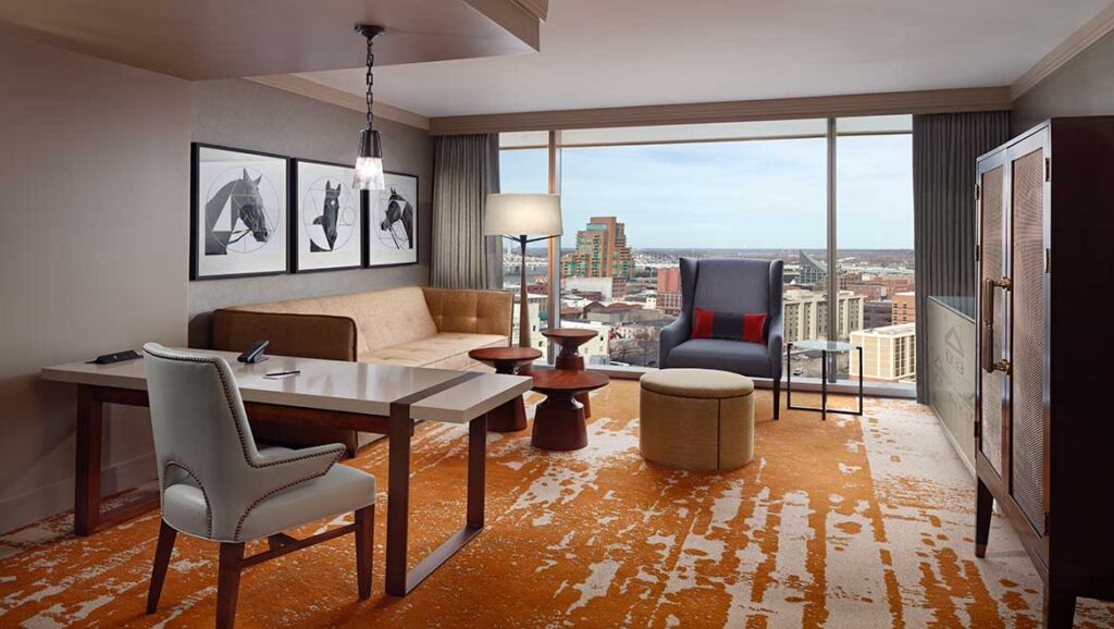 Luxurious corner suite living room at Omni Louisville Hotel, featuring stylish furnishings and expansive city views, ideal for travelers attending Kentucky Derby events near Churchill Downs.