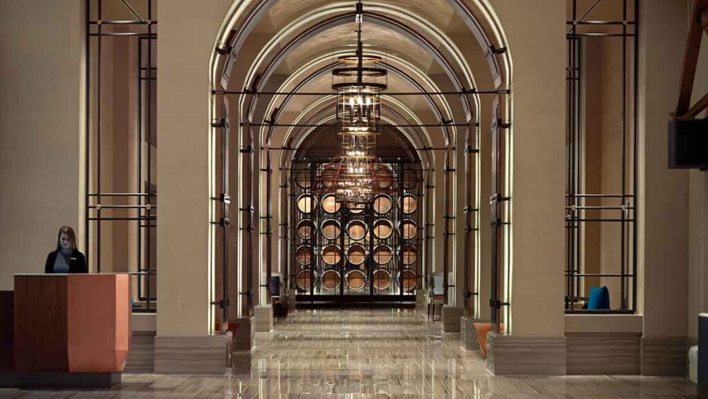 Interior view of Omni Louisville Hotel featuring an elegant hallway lined with barrel displays, ideal for guests visiting the Kentucky Derby.