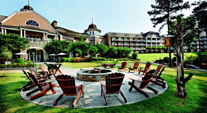 Luxurious hotel in Augusta, GA, featuring a beautifully landscaped courtyard with a fire pit and Adirondack chairs, perfect for accommodations near Greensboro and Augusta.