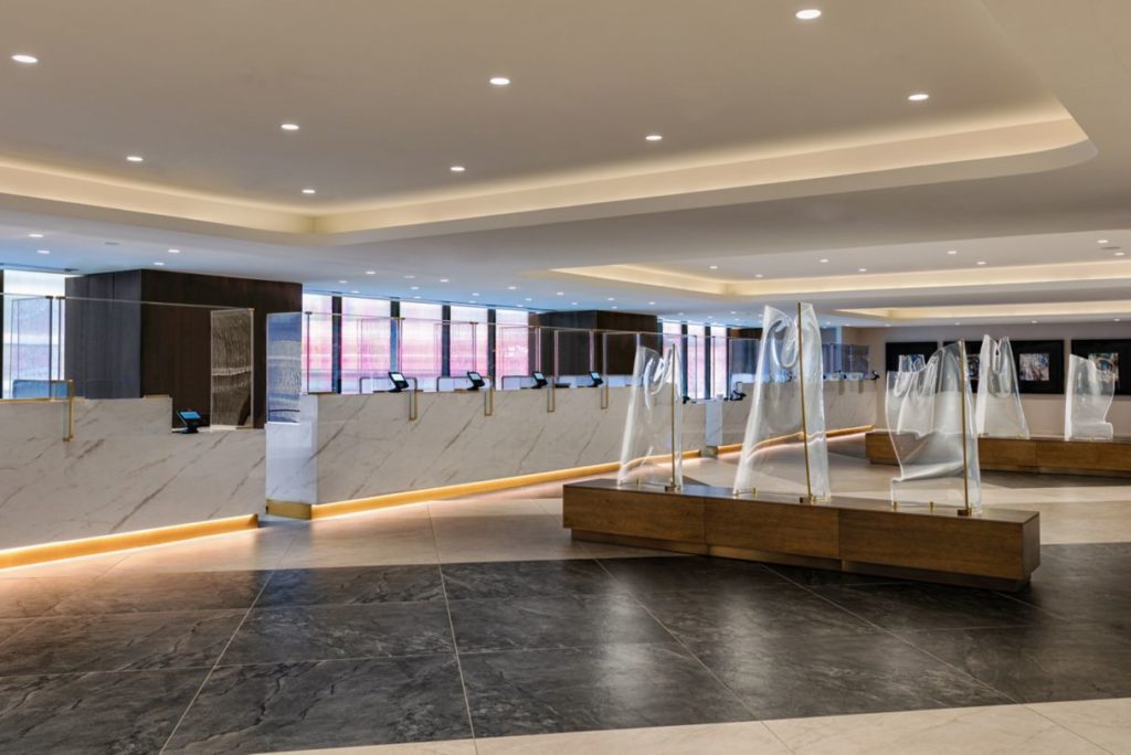Luxurious reception area of New York Marriott Marquis with elegant marble desks and soft lighting, located near US Open tennis accommodations.