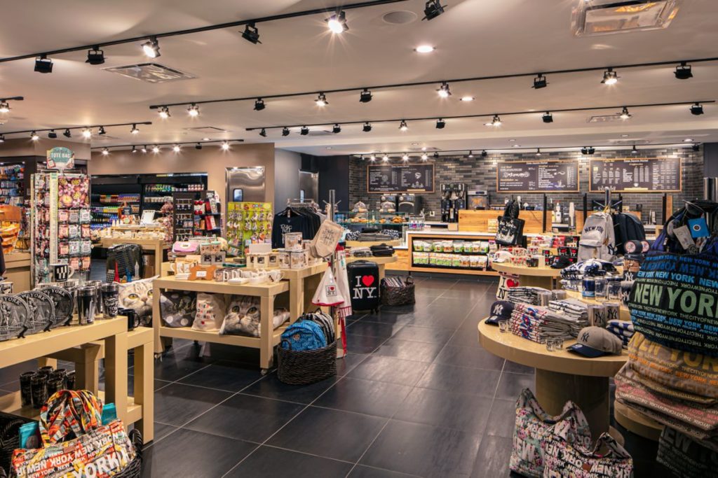 Interior of a busy gift shop at New York Marriott Marquis displaying a variety of souvenirs and a coffee bar, appealing to guests seeking accommodations near US Open Tennis events.
