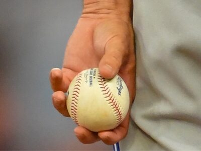 Close-up of a hand holding a baseball, illustrating the focus on sports at the MLB All-Star Game event.