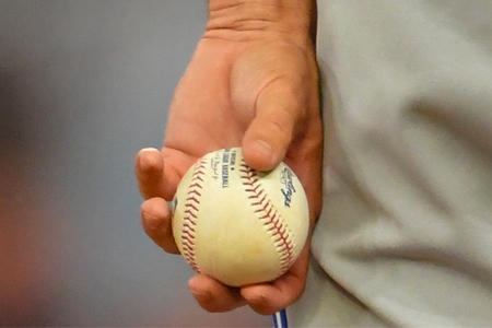 Close-up of a hand holding a baseball, illustrating the focus on sports at the MLB All-Star Game event.