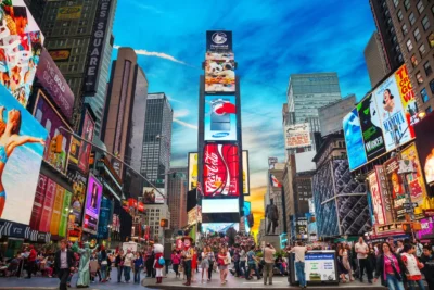 Vibrant scene at Times Square, New York, filled with pedestrians and bright digital billboards, showcasing an ideal setting for sports travel packages and luxury tours.