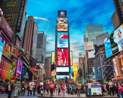 Vibrant scene at Times Square, New York, filled with pedestrians and bright digital billboards, showcasing an ideal setting for sports travel packages and luxury tours.