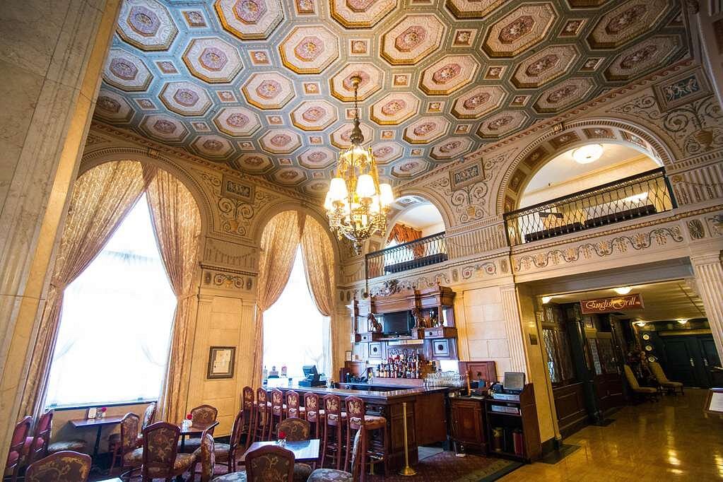 Interior of a grand hotel lobby in Louisville showcasing ornate ceilings and elegant furnishings, ideal for guests attending the Kentucky Derby near Churchill Downs.