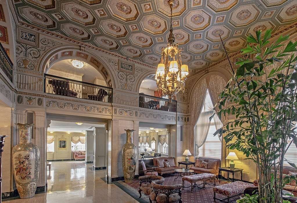 Luxurious hotel lobby near Churchill Downs featuring ornate ceiling details, elegant chandeliers, and classic furnishings, ideal for guests attending the Kentucky Derby.