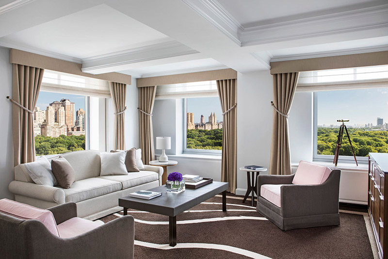 Luxurious hotel room at Ritz-Carlton Central Park with a view over Central Park, featuring elegant furnishings and large windows, ideal for US Open Tennis visitors in New York.