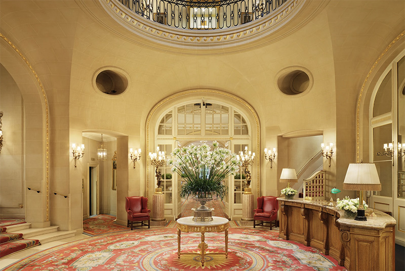 Elegant lobby of The Ritz London, featuring a large floral arrangement, opulent decor, and grand architecture, ideal for guests attending the Wimbledon Championships.