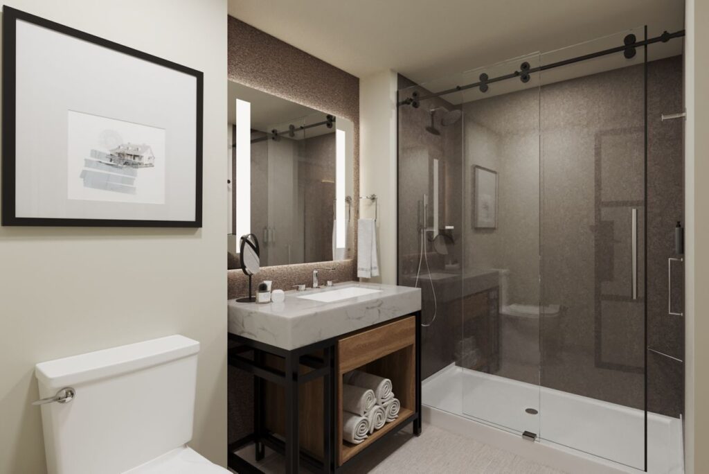 Modern bathroom in the Sheraton Augusta Hotel showcasing a large glass shower, marble vanity, and minimalistic decor, ideal for visitors seeking accommodations near Augusta's golf courses.